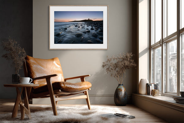 Ethereal Dawn coastal wall art featuring Northumbrian castle ruins, rocky shoreline and calm sea at sunrise
