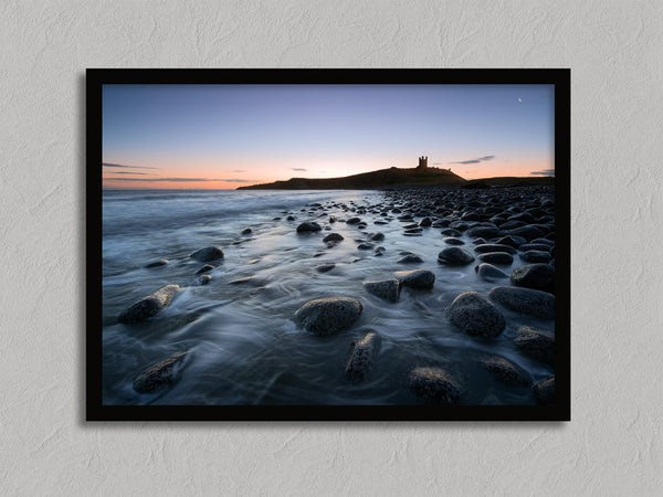 Ethereal Dawn coastal wall art featuring Northumbrian castle ruins, rocky shoreline and calm sea at sunrise