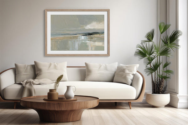 Pale Estuary, matted in a light wood frame, displayed above a white sofa and round coffee table.