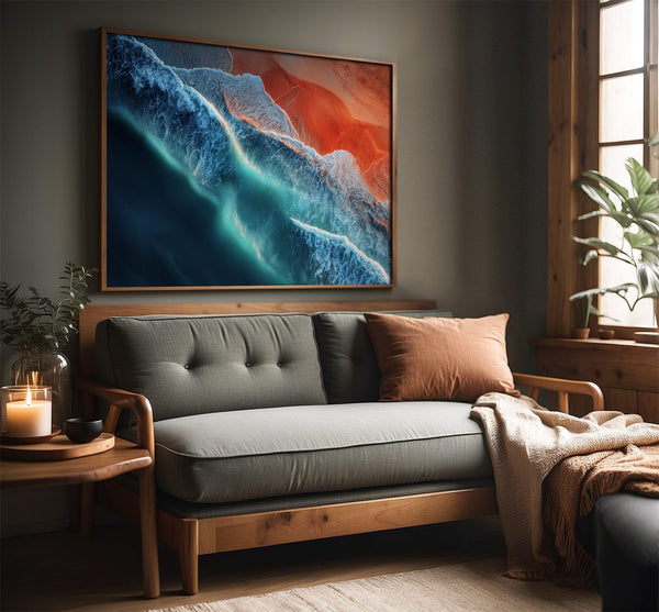 Ember Tide coastal artwork in a dark wood frame above a gray wooden sofa.