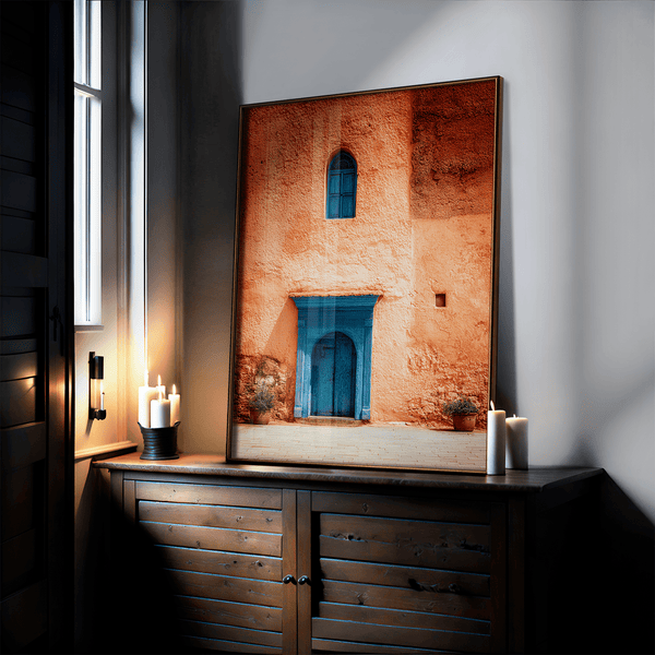 Framed Moroccan street scene art print featuring a vivid blue doorway and ochre wall. A soulful, timeless piece for eclectic interiors.