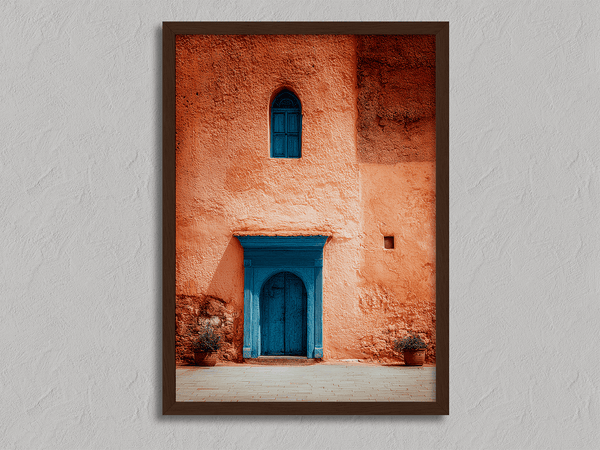 Framed Moroccan street scene art print featuring a vivid blue doorway and ochre wall. A soulful, timeless piece for eclectic interiors.
