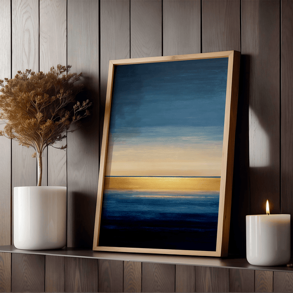 Framed wall art of an abstract seascape in deep indigo, blue, and gold. A minimalist horizon print evoking calm and renewal.