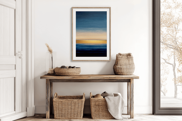 Framed wall art of an abstract seascape in deep indigo, blue, and gold. A minimalist horizon print evoking calm and renewal.