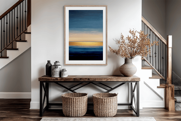 Framed wall art of an abstract seascape in deep indigo, blue, and gold. A minimalist horizon print evoking calm and renewal.