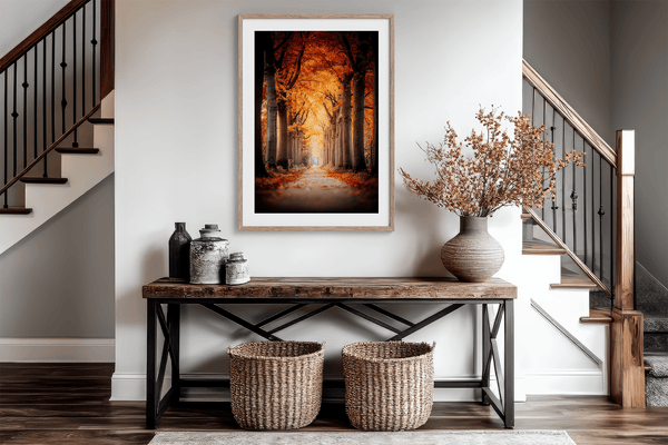 Framed wall art of a tree-lined autumn path beneath golden leaves. A nostalgic woodland print in warm light. Ready to hang.