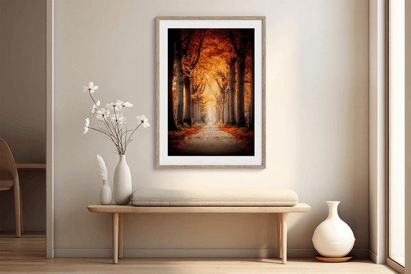 Framed wall art of a tree-lined autumn path beneath golden leaves. A nostalgic woodland print in warm light. Ready to hang.