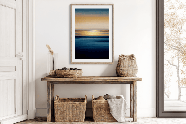 Framed wall art of an ocean sunset in coral, peach, and blue tones. A timeless abstract seascape print. Ready to hang.
