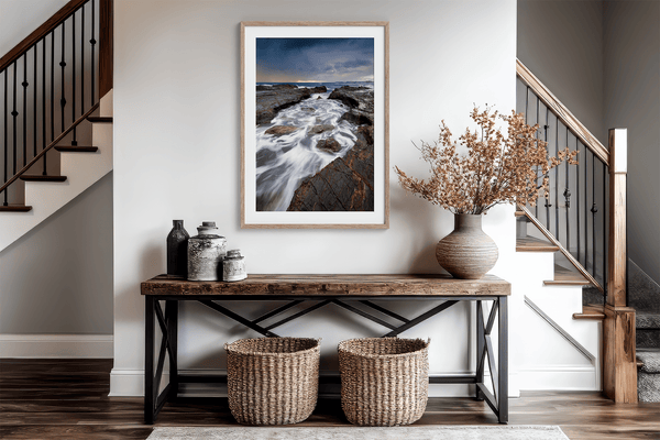 Framed wall art of the Australian coast with rugged rocks, azure sea, and moody skies. A striking coastal landscape print. Ready to hang.