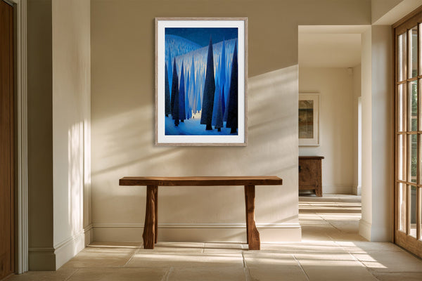 White-framed forest artwork hanging above a rustic wooden console in a sunlit corridor.