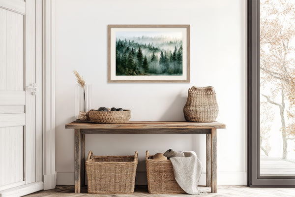 Light wood-framed misty forest artwork above a rustic console table with woven baskets.
