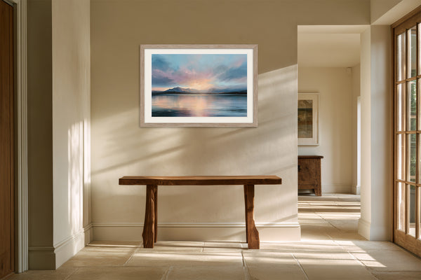 Light wood-framed mountain lake artwork above a rustic bench in a sunlit hallway.