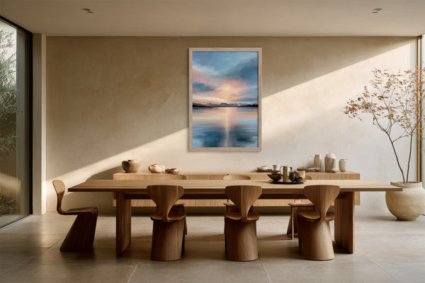 Light wood-framed mountain lake artwork above a long wooden dining table with sculptural chairs.