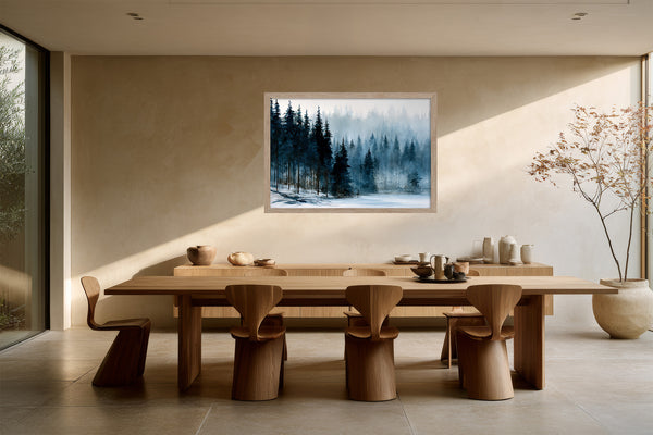 Framed winter forest artwork above a long wooden dining table with sculptural chairs.