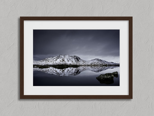 Silent Mirror shown in a walnut frame with a white border or mount.