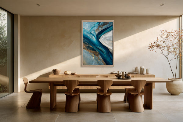 Framed teal and navy abstract artwork above a long wooden dining table with sculptural chairs.