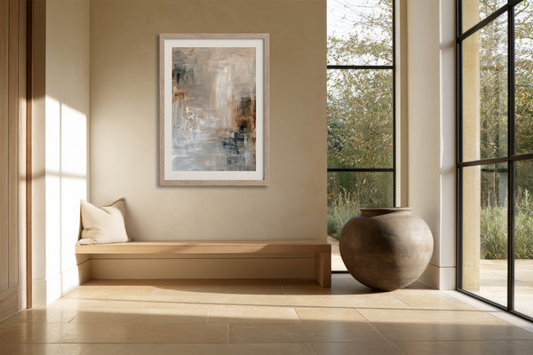 Framed beige and gray abstract artwork above a built-in bench beside tall windows.