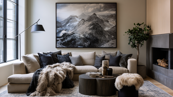 A contemporary living room features a large photographic print of majestic mountains above a neutral sofa