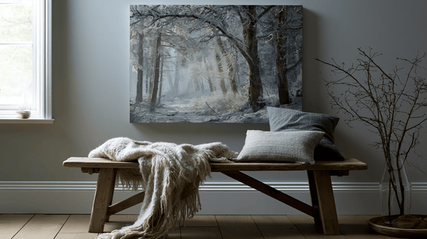 Misty forest canvas above a wooden bench with a wool throw and soft winter styling.