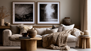A warm and elegant modern living room featuring black and white wall art above a soft linen sofa