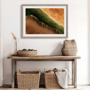 A framed landscape art print featuring a green and orange canyon scene