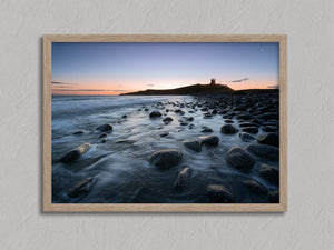 Ethereal Dawn coastal wall art featuring Northumbrian castle ruins, rocky shoreline and calm sea at sunrise