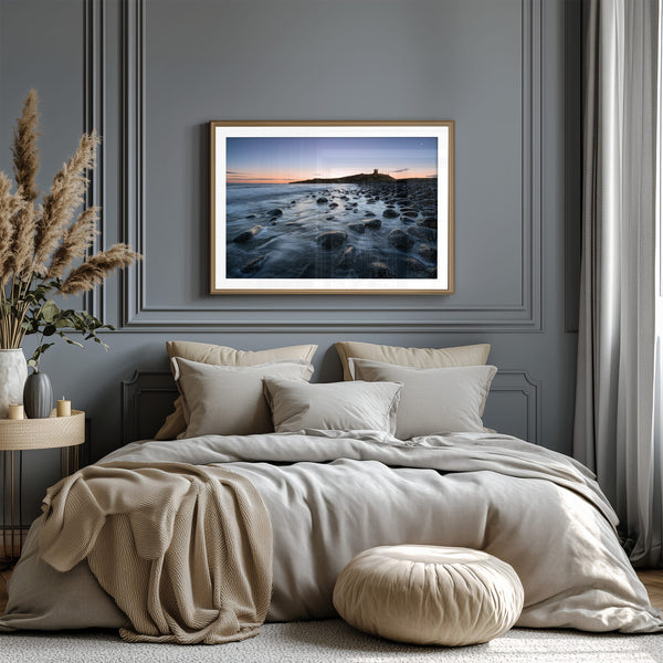 Ethereal Dawn coastal wall art featuring Northumbrian castle ruins, rocky shoreline and calm sea at sunrise