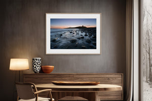 Ethereal Dawn coastal wall art featuring Northumbrian castle ruins, rocky shoreline and calm sea at sunrise