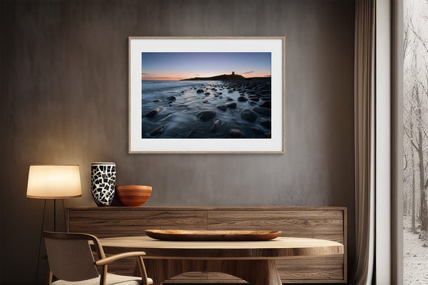 Ethereal Dawn coastal wall art featuring Northumbrian castle ruins, rocky shoreline and calm sea at sunrise