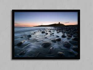 Ethereal Dawn coastal wall art featuring Northumbrian castle ruins, rocky shoreline and calm sea at sunrise