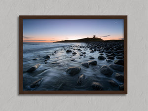 Ethereal Dawn coastal wall art featuring Northumbrian castle ruins, rocky shoreline and calm sea at sunrise