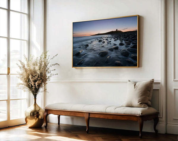 Ethereal Dawn coastal wall art featuring Northumbrian castle ruins, rocky shoreline and calm sea at sunrise