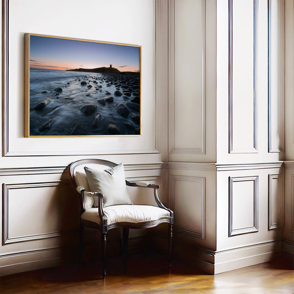 Ethereal Dawn coastal wall art featuring Northumbrian castle ruins, rocky shoreline and calm sea at sunrise