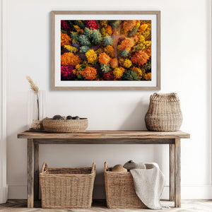 A large framed wall art print featuring a dense, colourful abstract floral or forest-like pattern in red, orange, yellow, green, and blue.