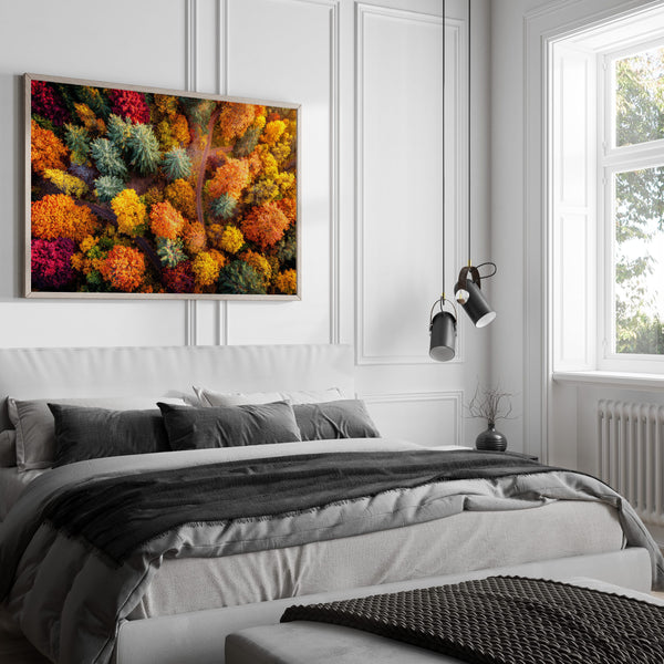 A large framed wall art print featuring a dense, colourful abstract floral or forest-like pattern in red, orange, yellow, green, and blue.