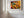 A large framed wall art print featuring a dense, colourful abstract floral or forest-like pattern in red, orange, yellow, green, and blue.