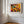 A large framed wall art print featuring a dense, colourful abstract floral or forest-like pattern in red, orange, yellow, green, and blue.