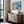 Abstract coastal artwork with layered blue waves, textured ivory forms and a warm golden shoreline.