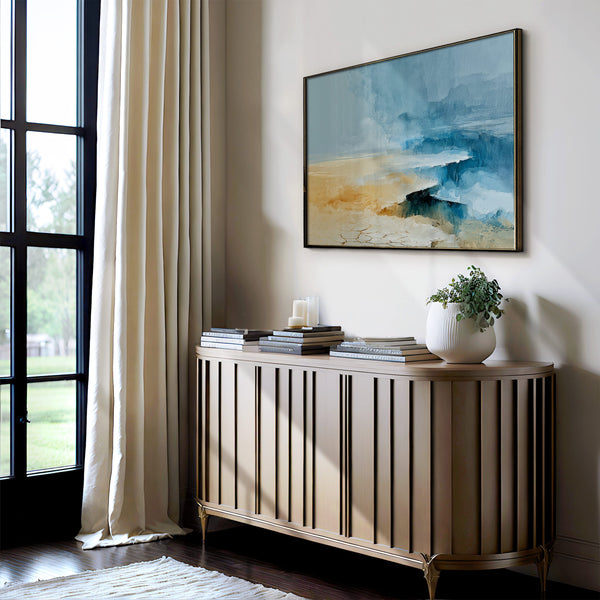 Abstract coastal artwork with layered blue waves, textured ivory forms and a warm golden shoreline.