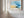 Abstract coastal artwork with layered blue waves, textured ivory forms and a warm golden shoreline.