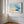 Abstract coastal artwork with layered blue waves, textured ivory forms and a warm golden shoreline.