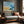 Abstract coastal artwork with layered blue waves, textured ivory forms and a warm golden shoreline.