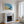 Abstract coastal artwork with layered blue waves, textured ivory forms and a warm golden shoreline.