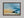 Abstract coastal artwork with layered blue waves, textured ivory forms and a warm golden shoreline.