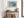 Abstract coastal artwork with layered blue waves, textured ivory forms and a warm golden shoreline.