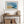 Abstract coastal artwork with layered blue waves, textured ivory forms and a warm golden shoreline.