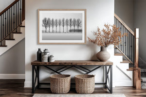 Black and white tree wall art featuring a row of bare winter trees across a minimalist snowy landscape