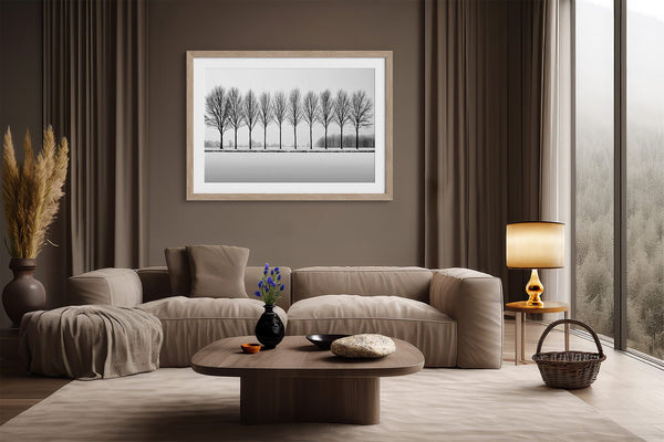 Black and white tree wall art featuring a row of bare winter trees across a minimalist snowy landscape