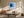 Black-framed blue abstract print above a cream sofa and low wooden coffee table.
