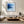 Black-framed blue abstract print above a low cream sectional and wooden coffee table.